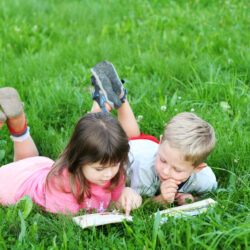 Kids reading a book outside on the grass | Nashville Christian Family Magazine - Free Christian Magazine