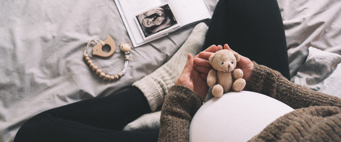 Unplanned Grandparenting - Pregnant woman holding small teddy bear | Nashville Christian Family Magazine - Free Christian Magazine