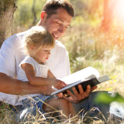 Father outside and reading to his young child | Nashville Christian Family Magazine - Free Christian Magazine