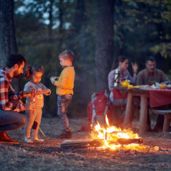 Family camping - Father & two children with family in the background | Nashville Christian Family Magazine - Free Christian Magazine