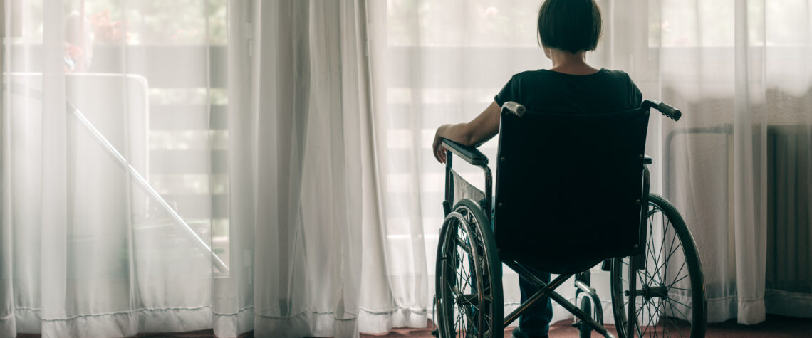 Woman sitting in a wheelchair by a curtained window | Nashville Christian Family Magazine - Free Christian Magazine