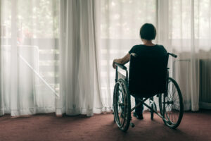 Woman sitting in a wheelchair by a curtained window | Nashville Christian Family Magazine - Free Christian Magazine