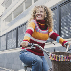 You are More than Your Divorce - Woman smiling while she rides a bicycle in an urban setting | Free Issue of the Nashville Christian Family magazine - Free Christian Magazine