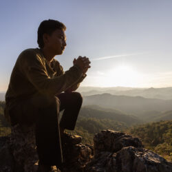 Darkness to Light - Silouette of man praying with mountains in the background | Free Issue of the Nashville Christian Family magazine - Free Christian Magazine