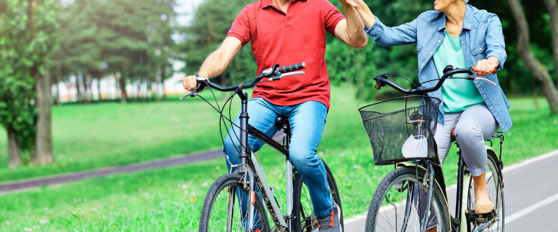 Information Overload over your health | Portrait of 2 happy & smiling seniors riding bicycles | April 2023 issue \ Nashville Christian Family Magazine