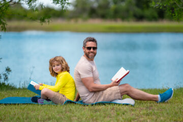 5 Summer Reading Tips for Parents - Father & son reading outside | Nashville Christian Family Magazine - June 2023 issue - Free Christian Magazine