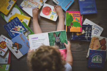 Young child looking at a book with a Rabbit , | Nashville Christian Family Magazine